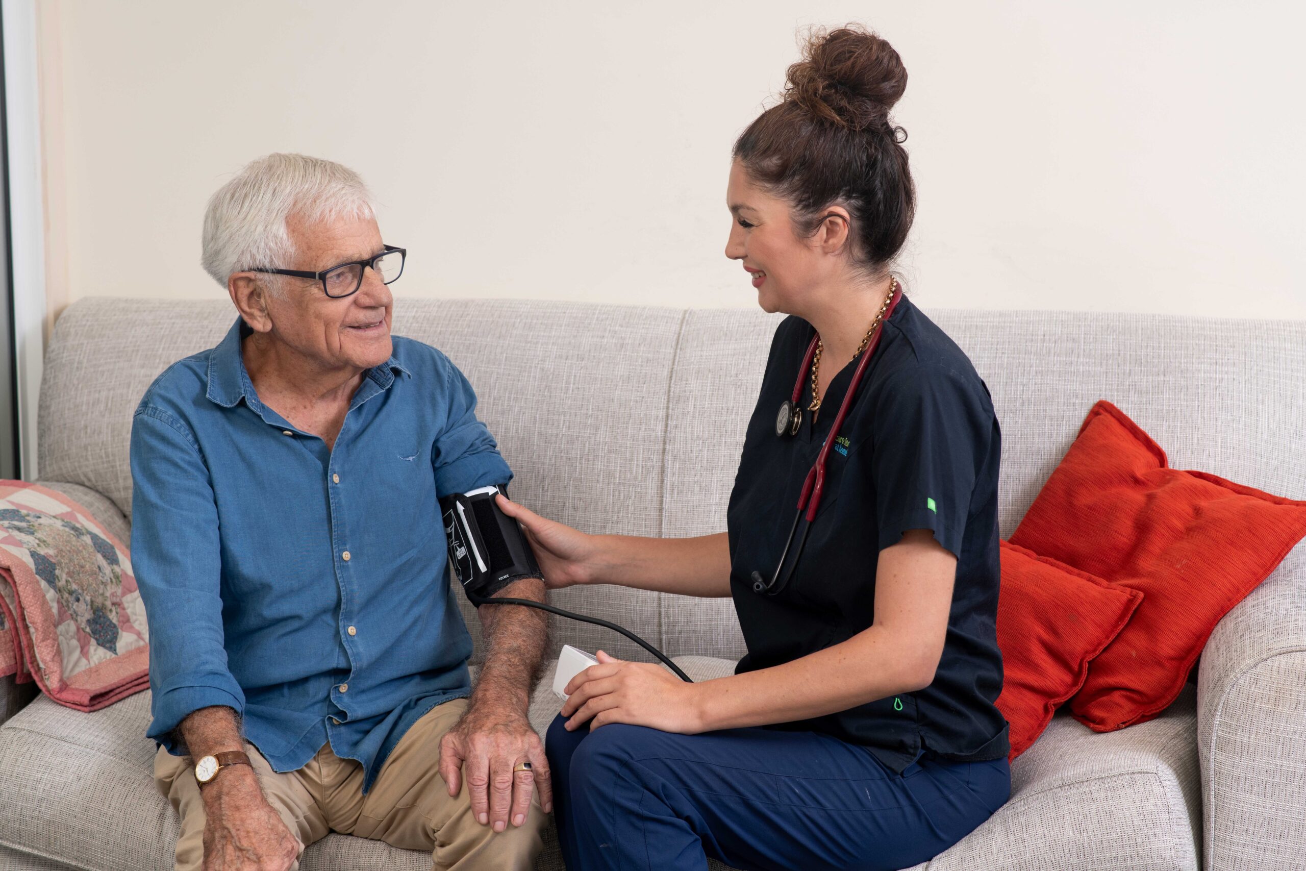 A Care For You at Home staff member taking the blood pressure of a senior man