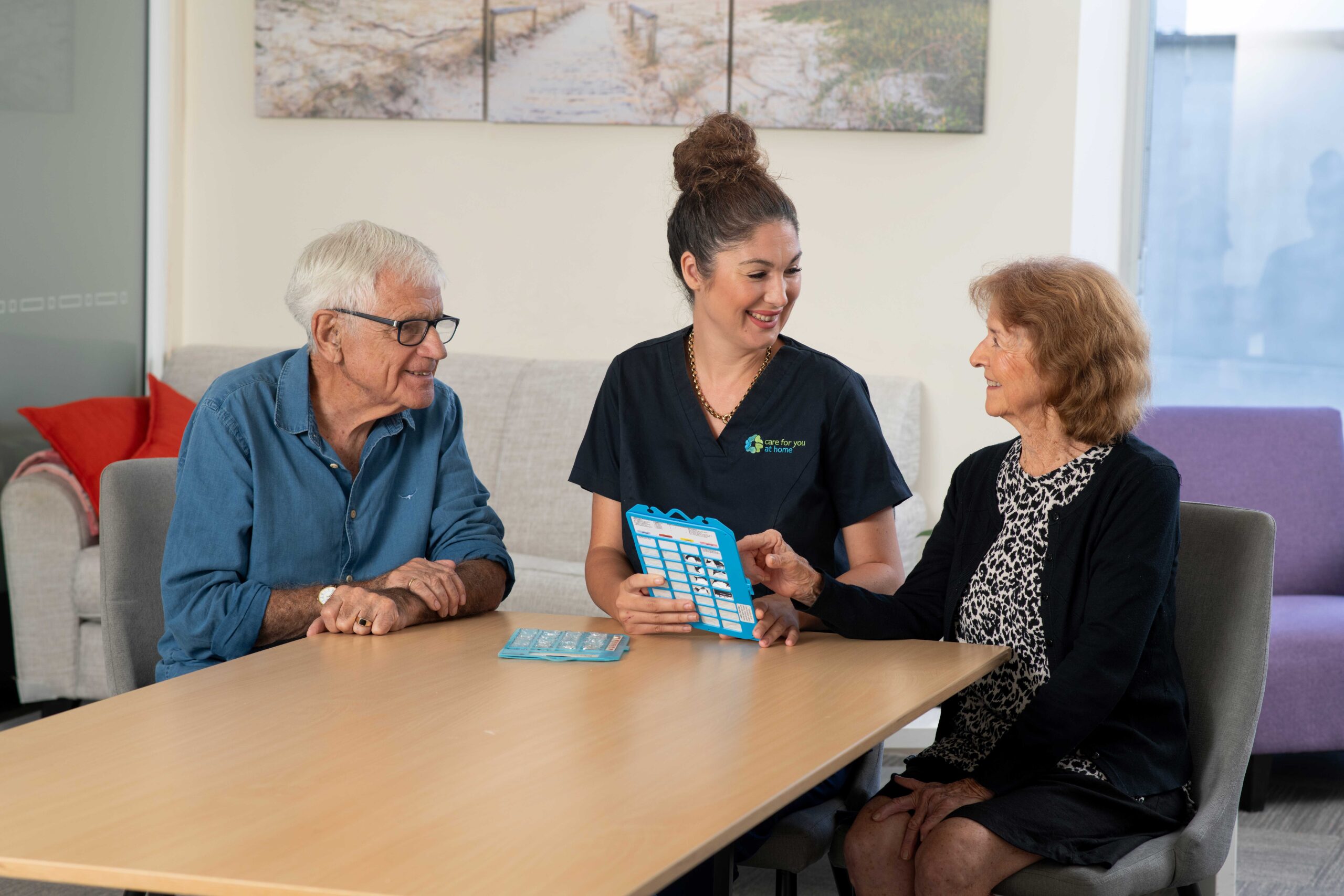 A Care For You at Home staff member seated with a senior man and woman